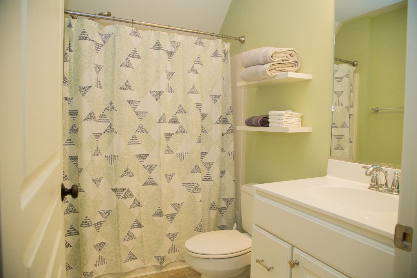 Bathroom with Green Wall Paint, Shower Curtain and Large Mirror