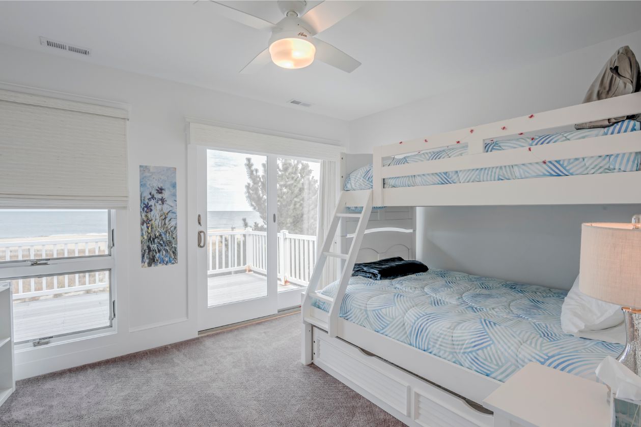 Bedroom with White Bunk Beds and White Ceiling Fan