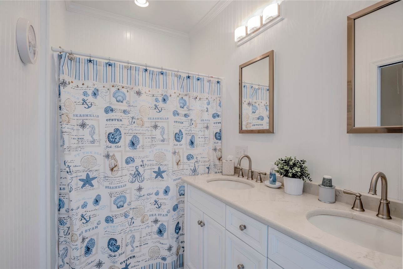Bathroom with Sea Themed Shower Curtain and White Vanities