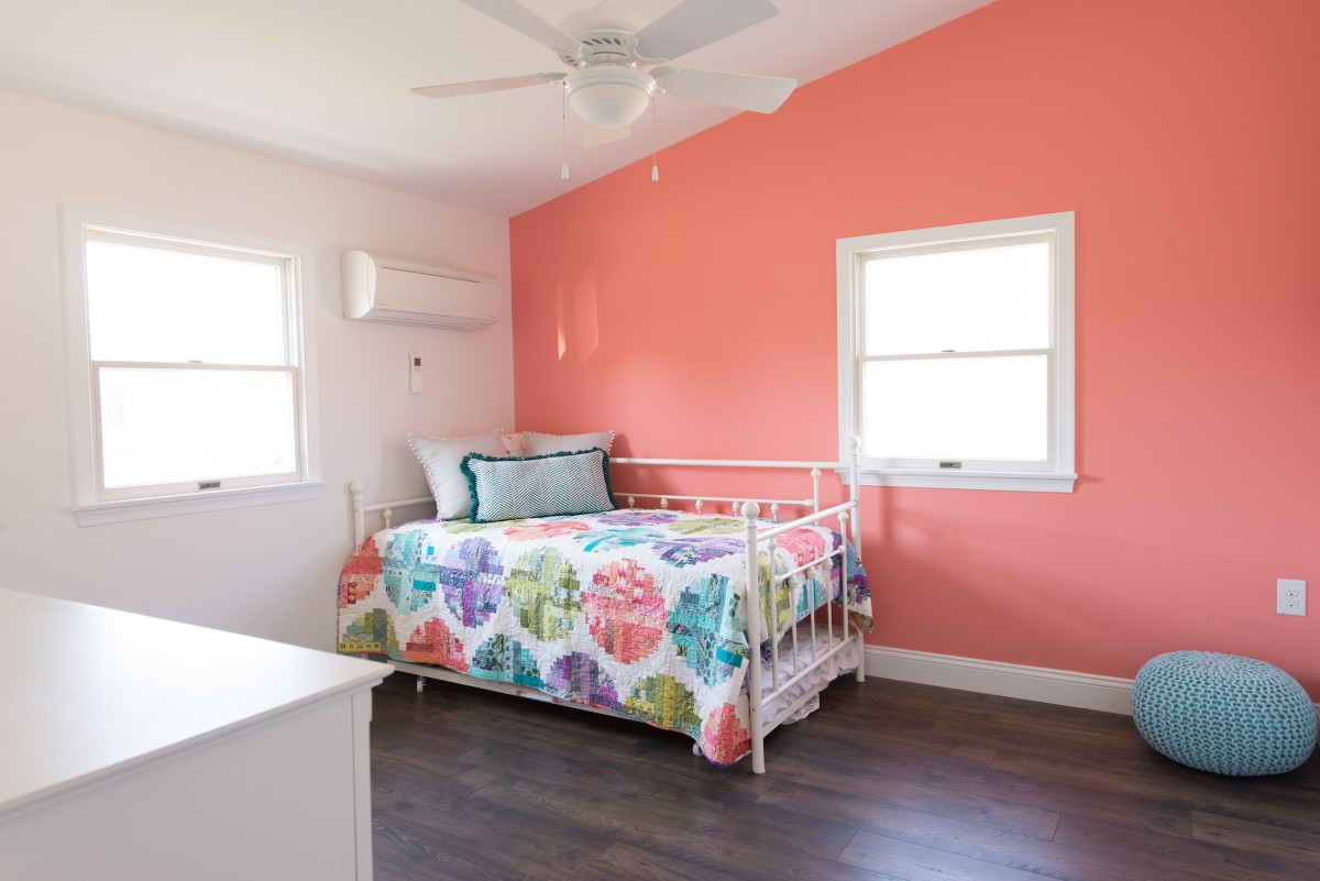 Kent Renovation Guest Bedroom with Coral and White Paint Walls, Dark Wood Flooring, Two Windows and Air Conditioner