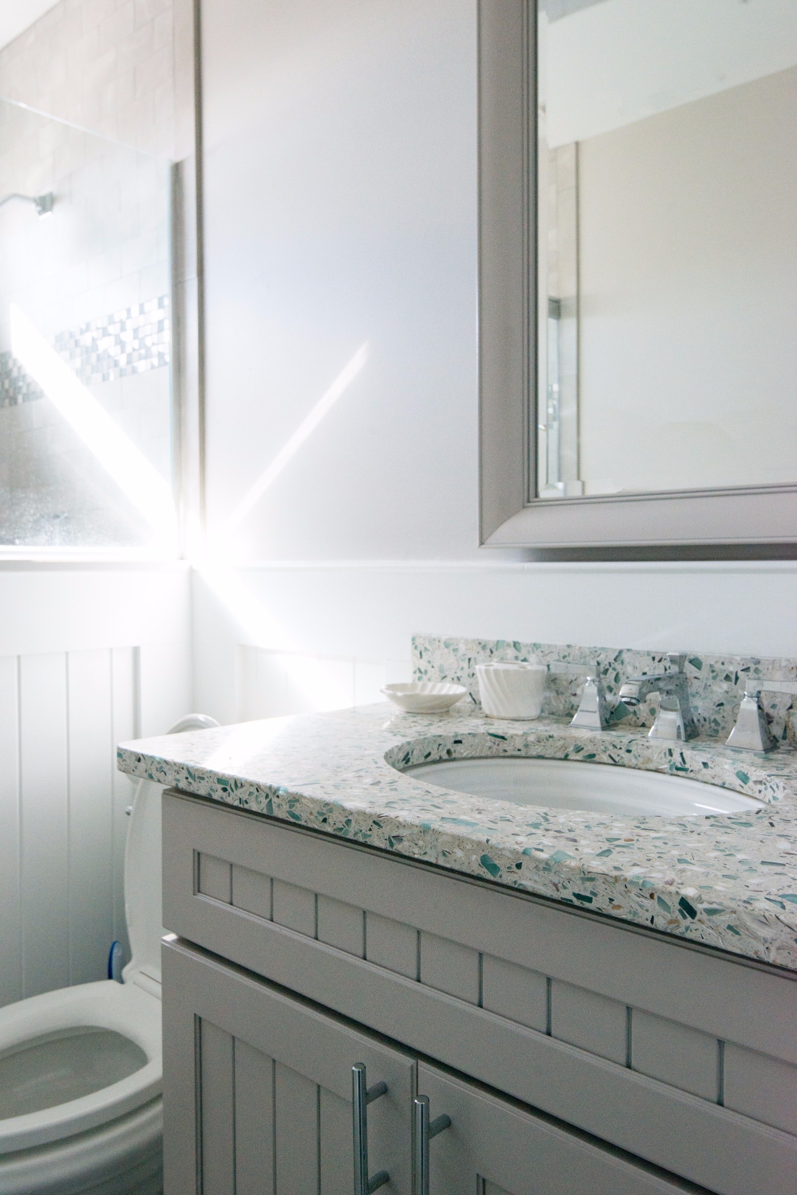 Bathroom Remodel in Kings Grant, Fenwick Island DE with White Wood Vanity, Vetrazzo Blue Countertop and Framed Mirror