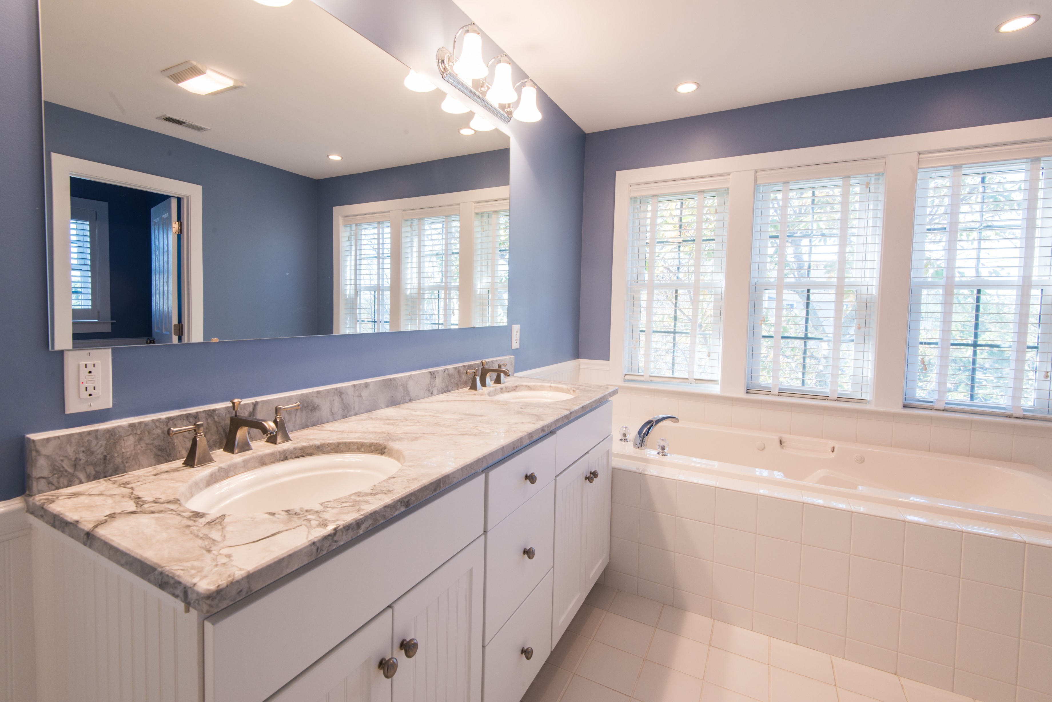 Bathroom Remodel in Ocean Ridge, Bethany Beach DE with Large Mirror, White Wood Vanity, Light Grey Countertop and Bathtub