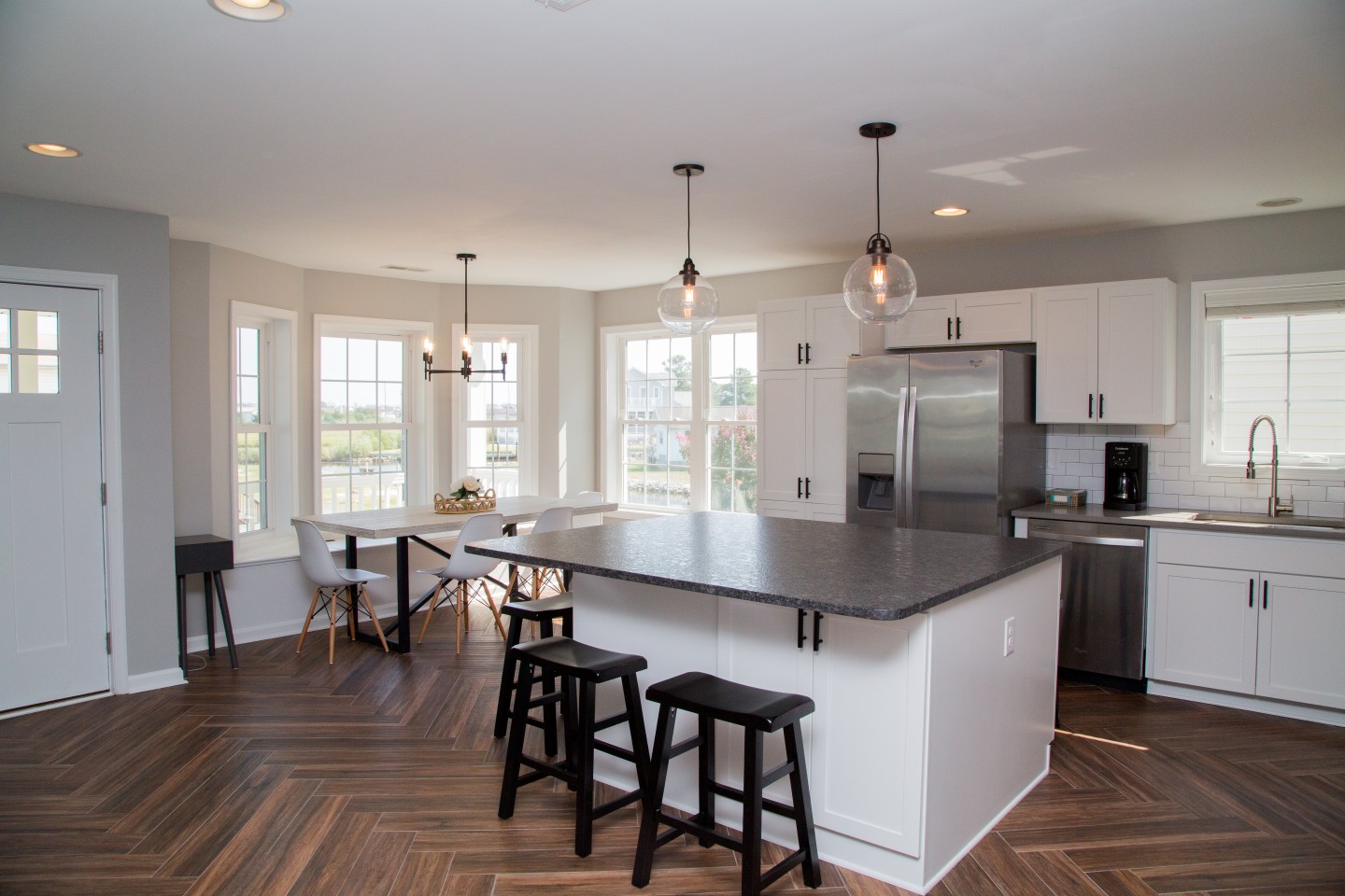 Kitchen Renovation with Hardwood Flooring, Large Windows and White Tile Backsplash